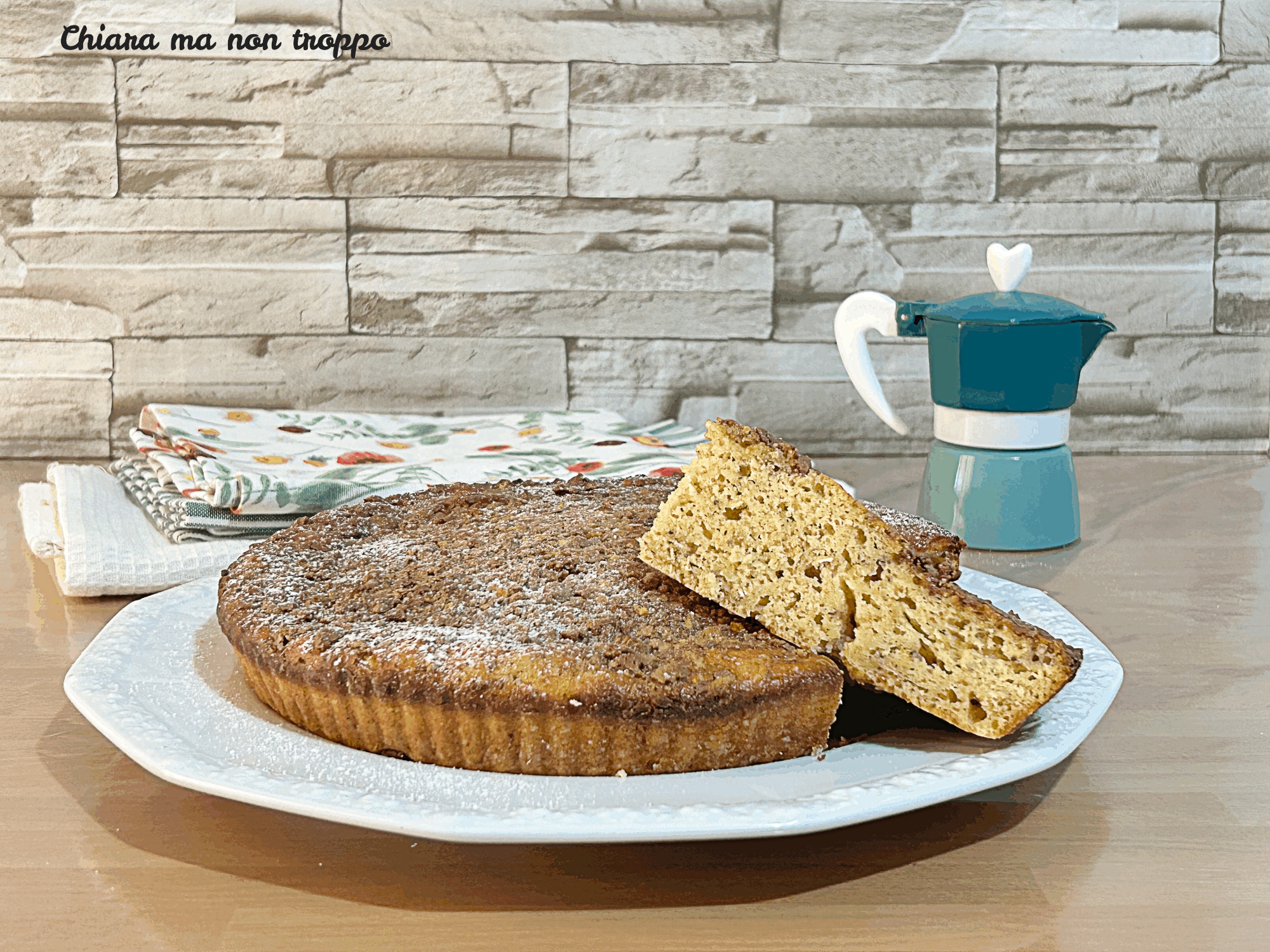 Torta rustica allo yogurt e avena con scaglie di cioccolato in superficie, servita su un piatto di ceramica.