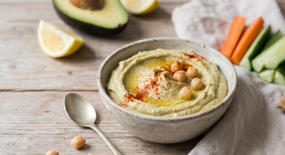 Hummus di ceci e avocado in una ciotolina con un filo d’olio, paprika e bastoncini di verdure