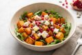 Insalata tiepida di zucca, feta e melagrana, colorata