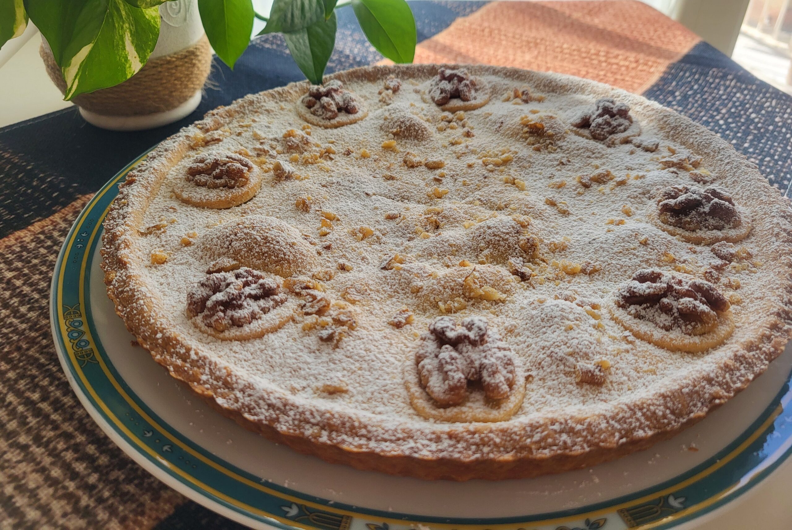 Crostata settembrina con marmellata di fichi e noci, decorata con noci e zucchero a velo e noci . Servita su piatto