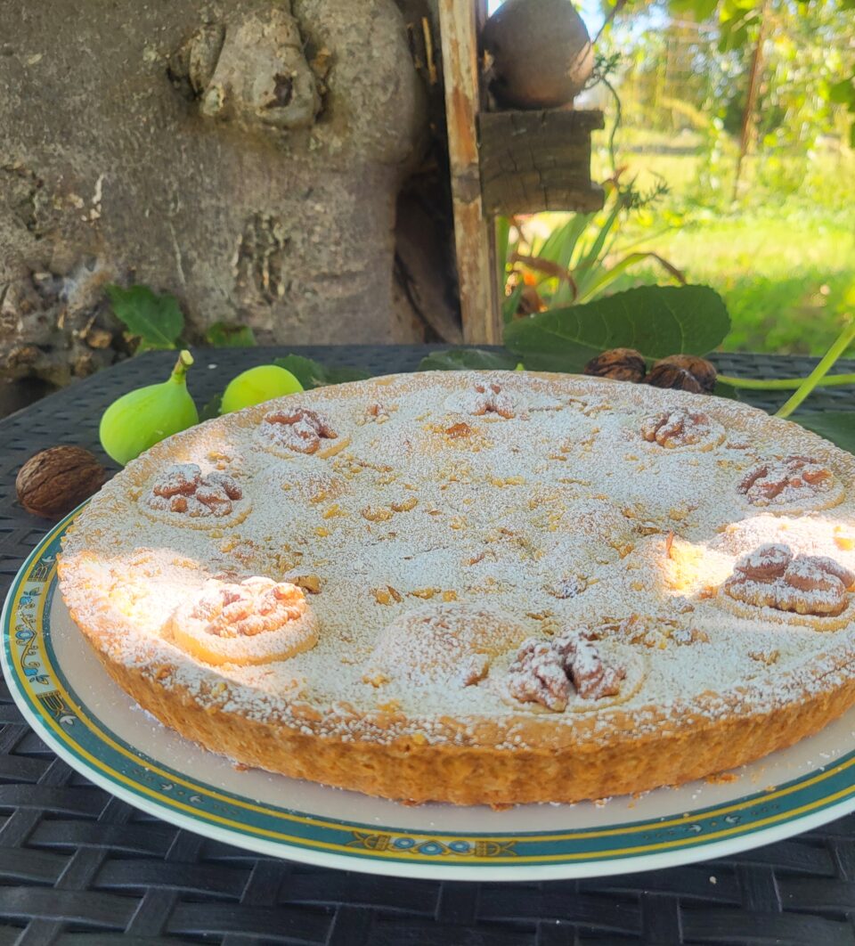 Crostata settembrina con marmellata di fichi e noci , decorata con zucchero a velo e noci ,servita su piatto 